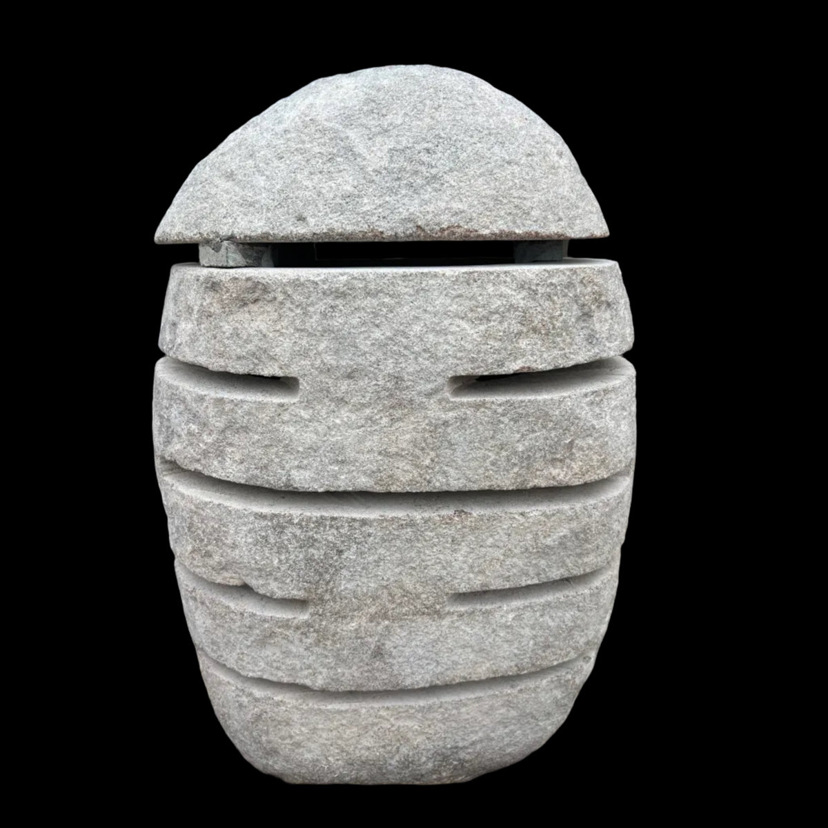 A beige slotted stone lamp designed for outdoor or indoor use, with slots cut into the stone to allow light to pass through.