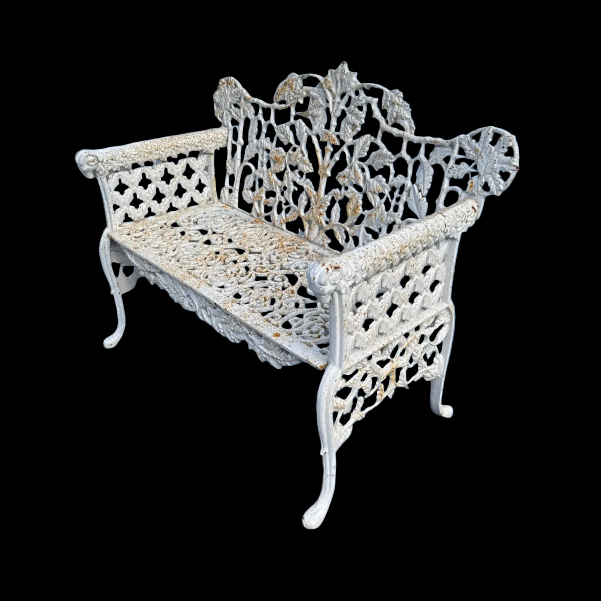 Decorative metal bench with intricate designs on a paved surface