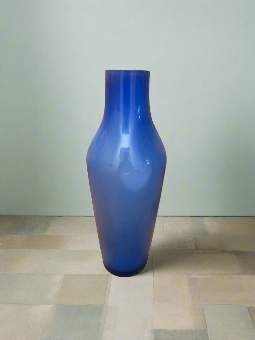 Blue Foggy Glass Vase on tiled floor next to painted wall