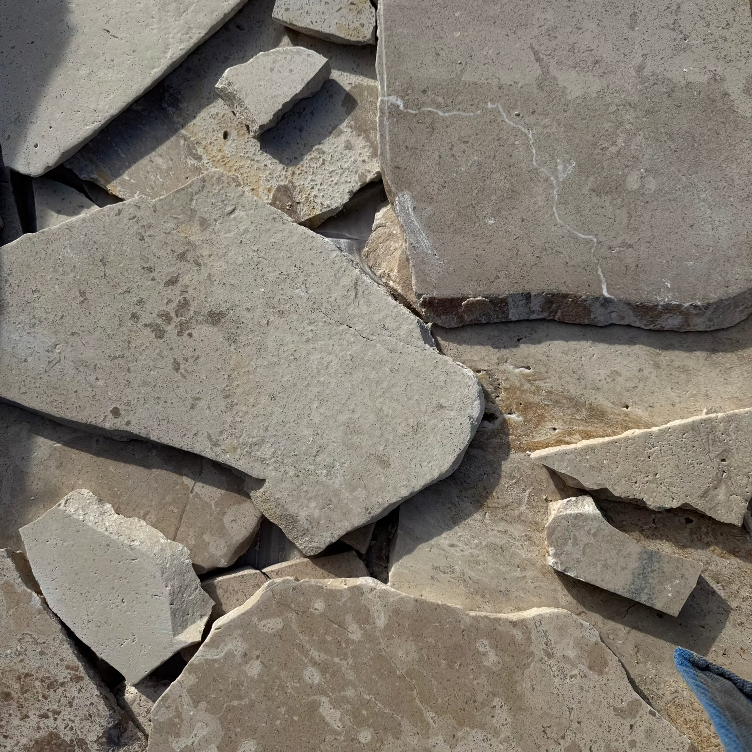 Close-up of stacked stone slabs with varying sizes and textures.