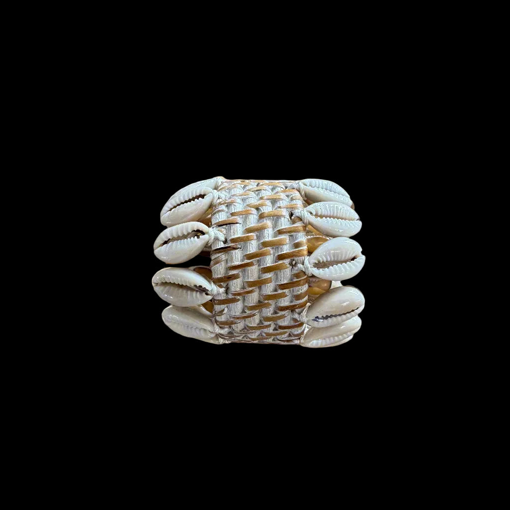 rattan and cowrie shell napkin holder on wooden table top