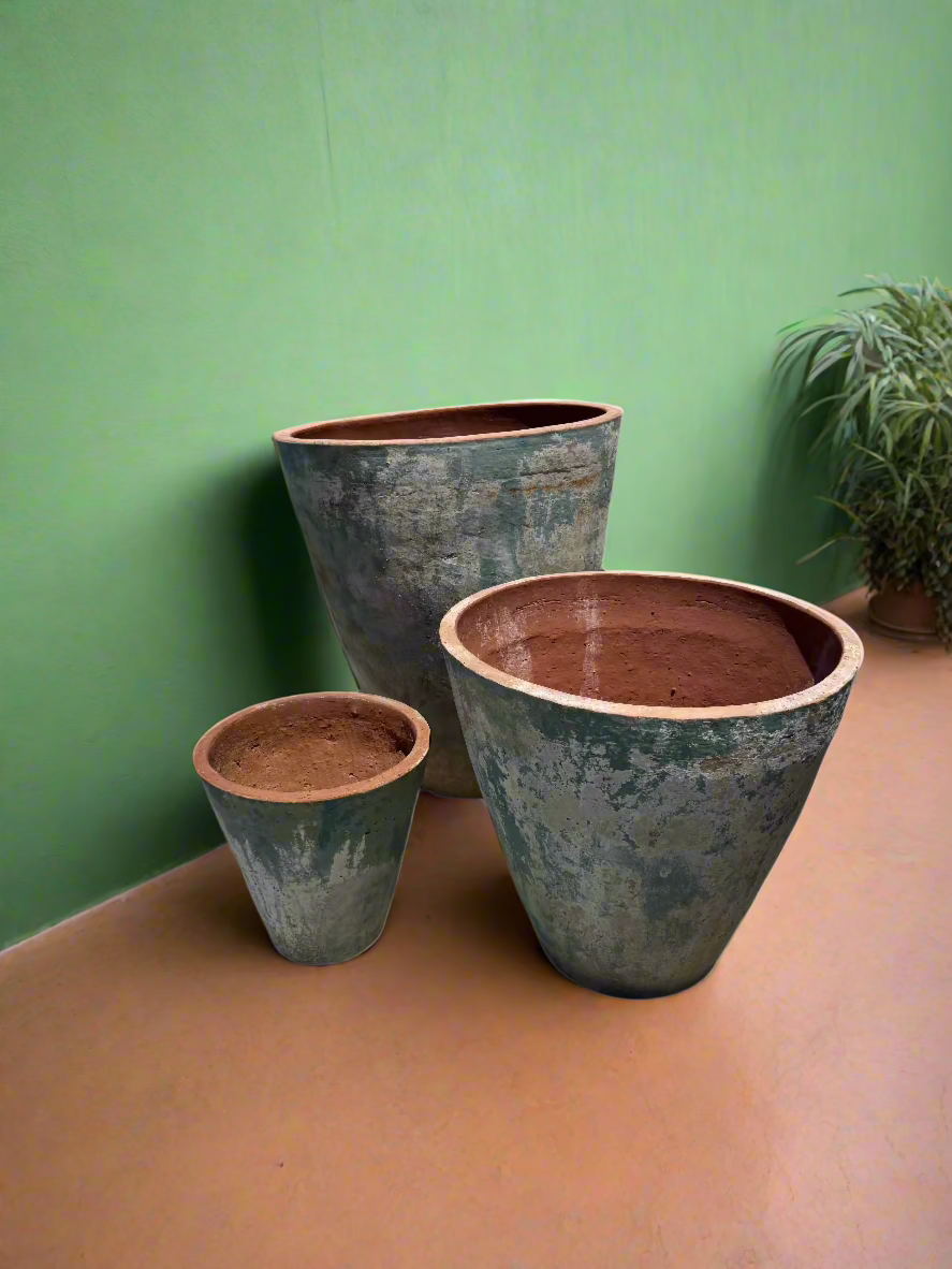 xl ancient tall cone tree garden pot planters in three different sizes with a faded blue patina next to a green rendered wall with terracotta floor tiles