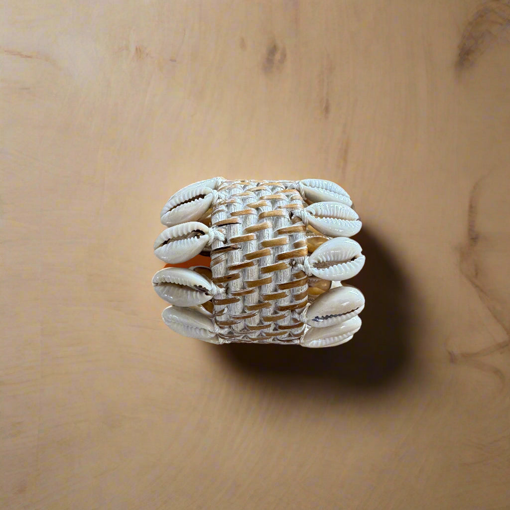 rattan and cowrie shell napkin holder on wooden table top
